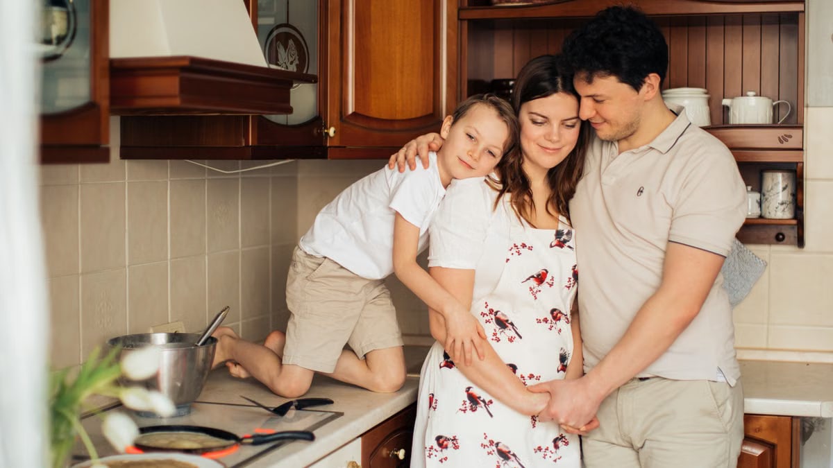 A joyful family of three embracing in their cozy kitchen, filled with love and warmth.